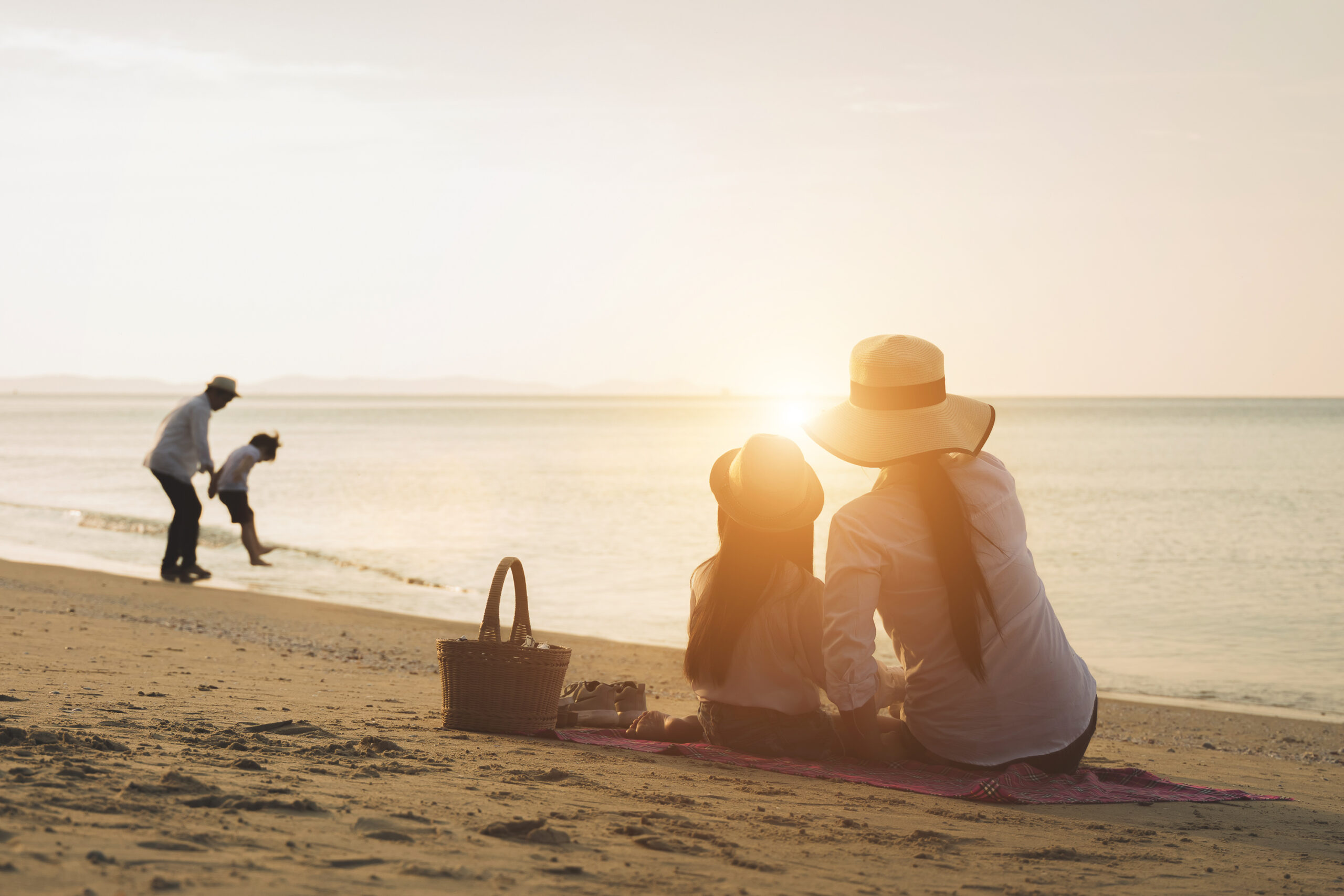 Family walking together along peaceful shoreline at golden hour